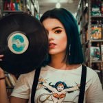 chica con disco de vinilo en biblioteca