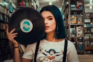 chica con disco de vinilo en biblioteca